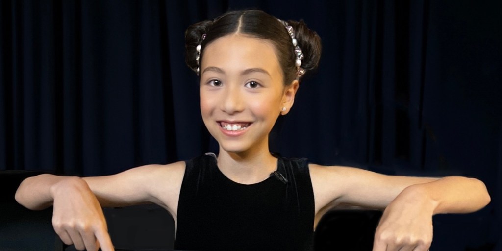 Magician Rachel Ling Gordon in a black dress pointing down