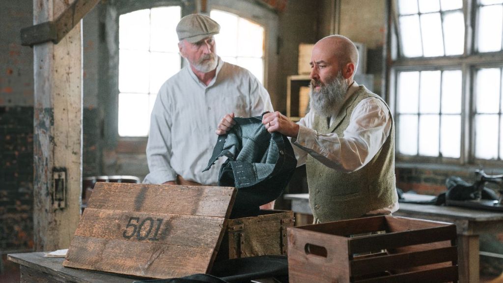 Jacob Davis inspecting a pair of 501 jeans in The Mega-Brands That Built America. (Photo Credit: A&E Television Networks/Lucky8, Courtesy of HISTORY.)
